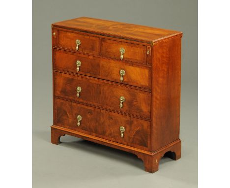 A late 19th century Georgian style walnut bachelors chest, with turnover top, two and three long drawers with brass drop hand