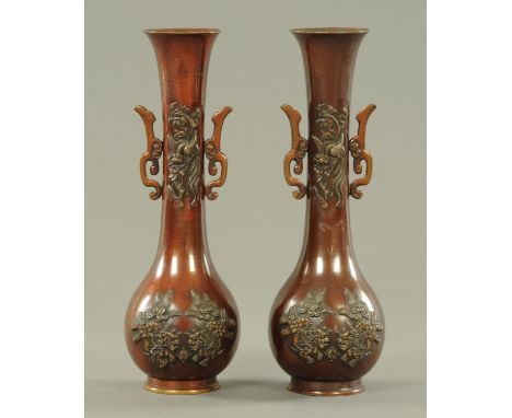 A pair of Chinese bronze twin handled vases, late 19th century, with slender necks with relief Feng and flowers above two Chi