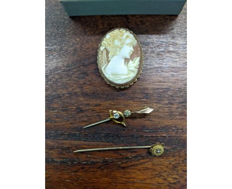 A yellow metal cameo carved brooch together with a yellow metal diamond inset stick pin and a yellow metal brooch, 8.4gLocati