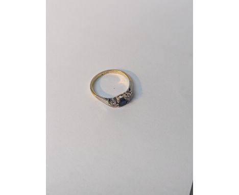 A 18ct gold two-tone ring, inset with central blue sapphire, flanked by diamonds, 2.7gLocation: 