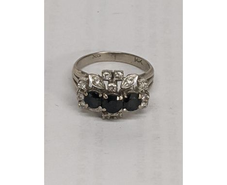 A 14ct white gold ring inset with diamonds and three blue sapphires, total weight 5.0gLocation: 