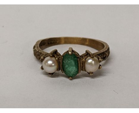 A 9ct gold emerald ring flanked by two cultured pearls, 2.6gLocation: 