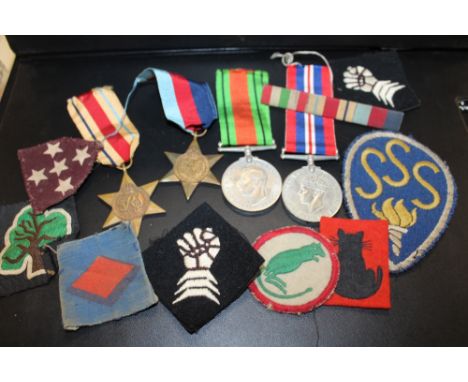 A VINTAGE OXO TIN CONTAINING WWII MEDALS TO INCLUDE AN AFRICA STAR EXAMPLE, PATCHES 