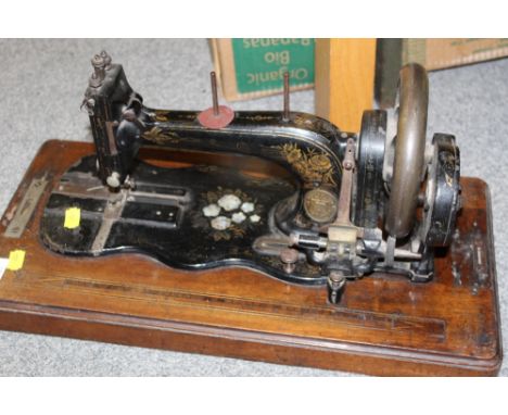 A CASED ANTIQUE SEWING MACHINE WITH MOTHER OF PEARL INLAY STAMPED C &amp; K