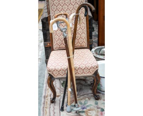 A collection of various walking sticks, comprising a late Victorian ebonised walking stick with a silver band, hallmarked for