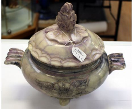 An alabaster raised bowl and cover, in an oriental style, the finial is a stylised lotus flower and the handles are styled as