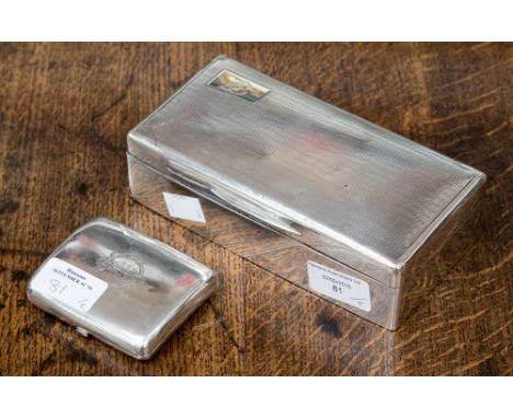 A silver cigarette box with engine-turned lid and cartouche to top left corner, B engraved, hallmarked London, 1925 (a/f) and