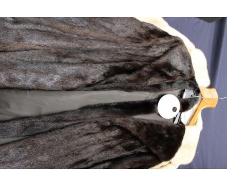 A very dark brown long length mink coat with waist best, hook and eye fastenings, single lapel collar, lining in good conditi