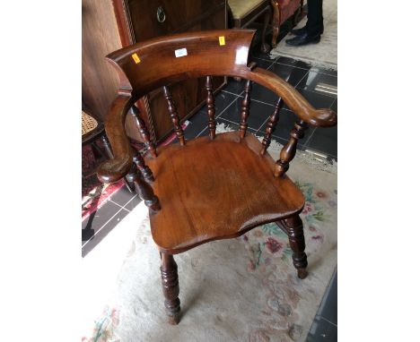 A 19th Century elm captain's chair, saddle seat and raised on turned legs