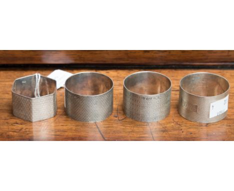 Three George VI silver serviette rings, all hallmarked H. Bros Birmingham 1943 with varied engine turned patterns, two with v
