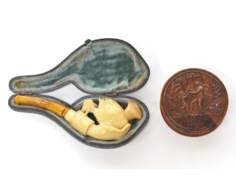 A 19th Century cased Meerschaum pipe with amber mouthpiece, carved as a double-yolk egg hatchling within hand, together with 