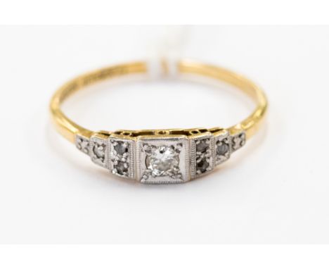 An Art Deco diamond, platinum and 18 ct yellow gold dress ring, the central gypsy set diamond weighing approx. 0.10 ct, flank