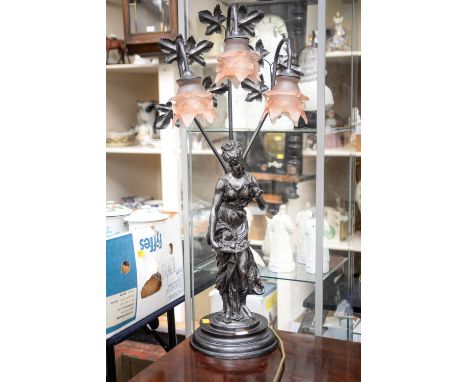 A reproduction Art Nouveau style table lamp, three peach glass shades, mounted with a figure of a fruit carrier