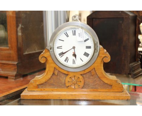 A mantel clock with metal clock case mounted on wooden arts and crafts style base, enamel dial (a/f) black Roman numerals 