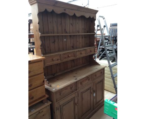 A Victorian style pine dresser and rack, the rack section with shelves and four spice drawers, the base with three drawers ov