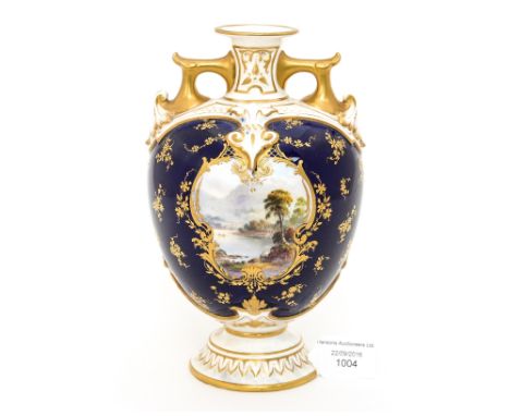 A Royal Worcester twin handled vase, ovoid pedestal form, decorated with a landscape Lakeland vignette within a cobalt blue g