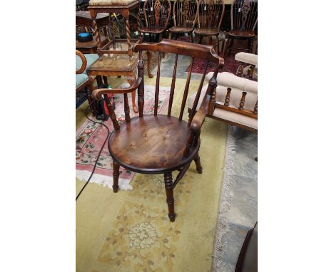 A late 19th Century birchwood captain's chair, shaped crest rail, solid seat and raised on turned legs