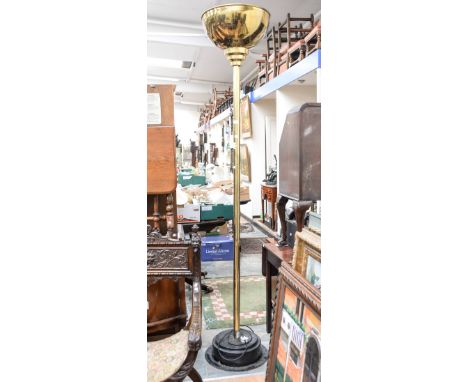 A large brass uplighter standard lamp with brass shade and black base