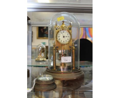 An early 20th Century brass anniversary clock, Arabic numerals, under a glass dome together with a small hanging clock with e