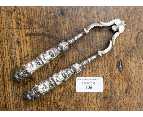 A white metal handled nut cracker, dated 1902 