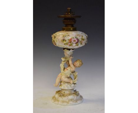 Late 19th Century German porcelain oil lamp having floral encrusted decoration, the column formed as a cherub   Condition: 
