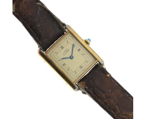 Must de Cartier - Silver gilt tank quartz wristwatch, the ivory dial having Roman numerals, on a brown leather strap, togethe