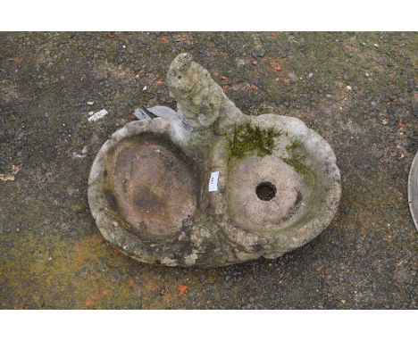 A concrete combination garden planter and bird bath with gnome decoration