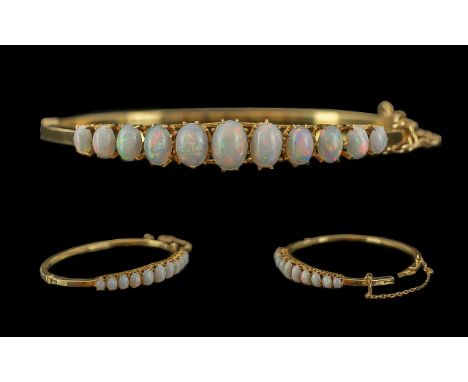 Victorian Period 1837 - 1901 Ladies 15ct Gold Opal Set Hinged Bangle with Safety Chain. Marked 15ct. The Graduated Opals of P