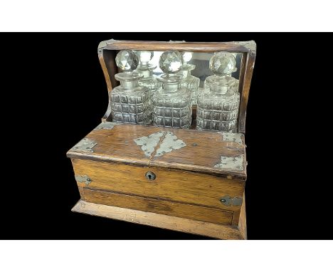 Vintage Wooden Tantalus with three decanters, two front compartments, and brass decoration.