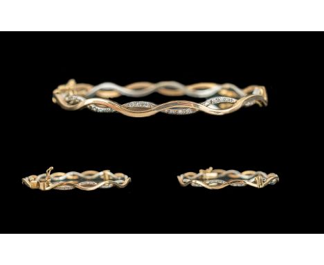 9ct Gold &amp; Diamond Set Bangle, wave design, in original box.  Hinged opening and clasp fastening.  Weight 8.8 grams.