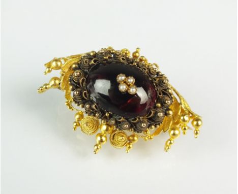 A 19th century garnet and seed pearl filigree brooch, the oval cabochon garnet set with four split seed pearls, all mounted w