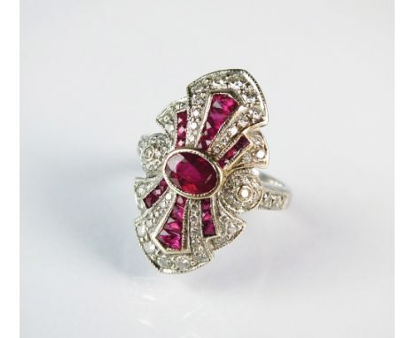 An Art Deco style ruby and diamond cluster ring, designed as a central oval mixed cut ruby collet set within tapering ruby an