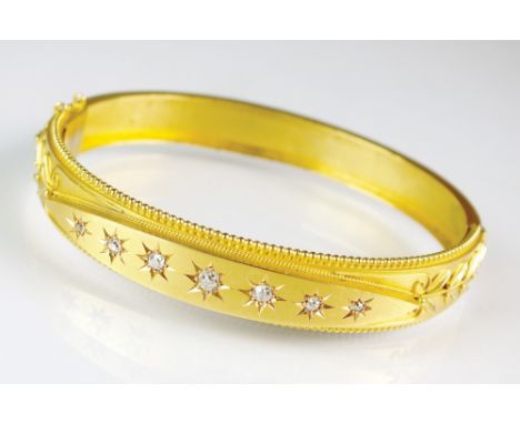 A late 19th century seven stone diamond set bangle, the seven graduated old cut diamonds star set within navette shaped panel