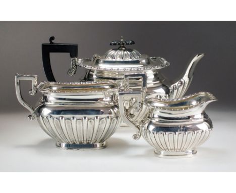 An Edwardian three piece silver tea service, William Devenport, Birmingham 1908, comprising; a teapot with ebonised handle an