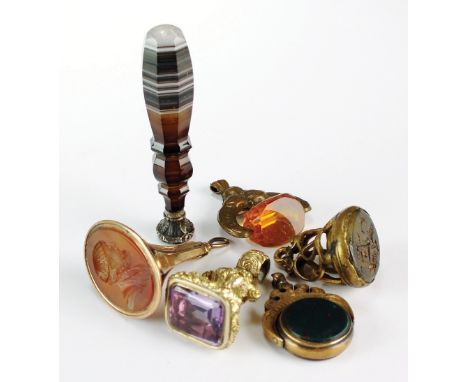 A banded agate desk seal, together with a carnelian set seal fob, a swivel fob, an amethyst set fob and two further fobs (6)
