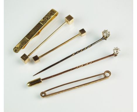 A diamond set stick pin, together with a 9ct gold bar brooch, a 9ct gold tie clip, two 9ct gold cloak pins and a paste set st