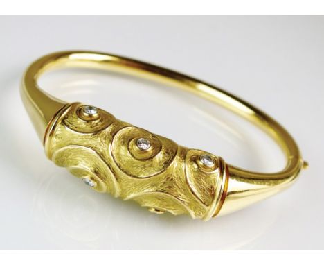 An 18ct gold diamond set hinged bangle, designed as five brilliant cut diamonds collet set to textured spiral and mounted wit