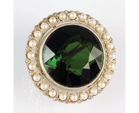 An early 20th century green tourmaline, pearl and diamond brooch, designed as a single round mixed cut tourmaline measuring a