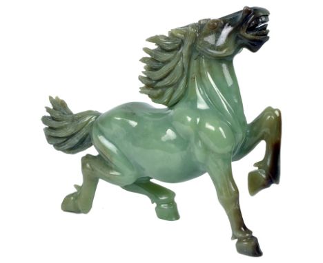 A Chinese Jade Carving:
Mid-20th century
Of an overall celadon tone with some darker streaks. Vigorously modelled as a gallop