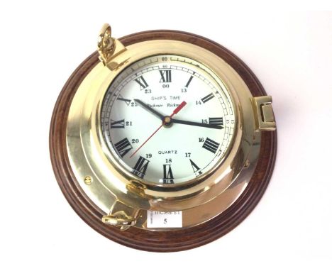 BRASS SHIPS BULKHEAD CLOCK, 20TH CENTURY the circular dial with Roman numerals, fitted to a wooden plaque27.5cm wide