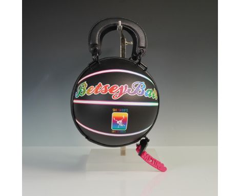 This playful and bold Betsey Johnson BetseyBall handbag is designed in the shape of a basketball with a sleek black faux leat