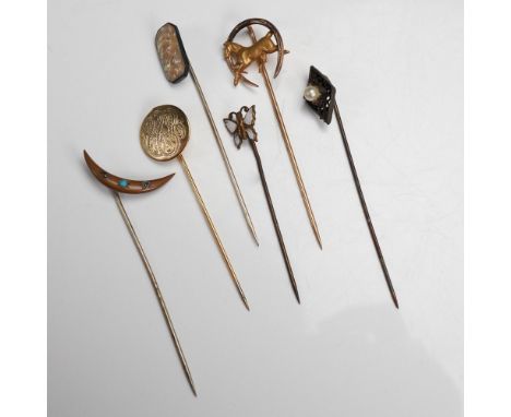 An eclectic collection of six antique hat pins, showcasing intricate craftsmanship and turn of the century decorative styles.