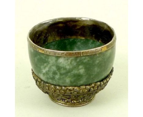 A 19th century jade and Chinese white metal mounted cup, with covered rim, the base decorated with good luck symbols, upon a 