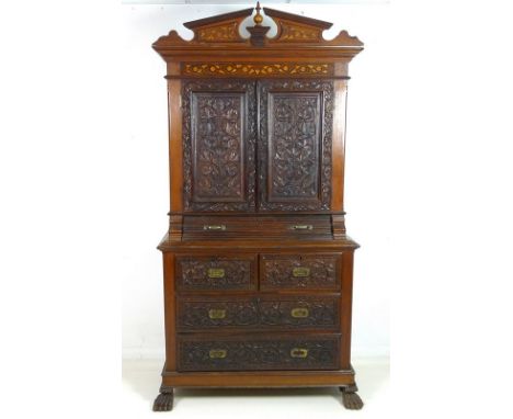 A Colonial hardwood padouk bookcase, with floral carving, and inlaid decoration, blind carved doors, architectural cornice, a