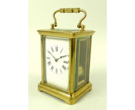 A 19th century French brass carriage clock with striking movement on a chime, the white enamel face with black Roman numerals