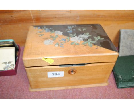 A walnut and decorated trinket box, the contents to include various thimbles, small embroidery etc.