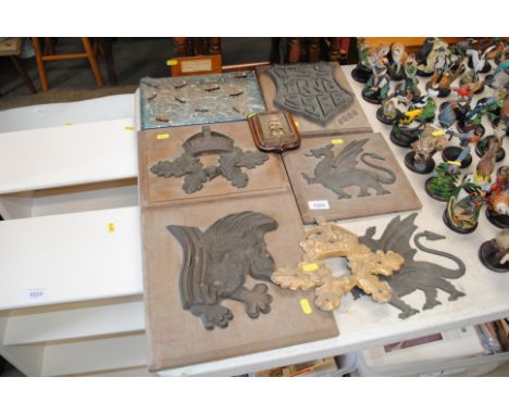 A collection of various bronze, gilt and cast iron crests including two Welsh dragon examples and a small diorama model