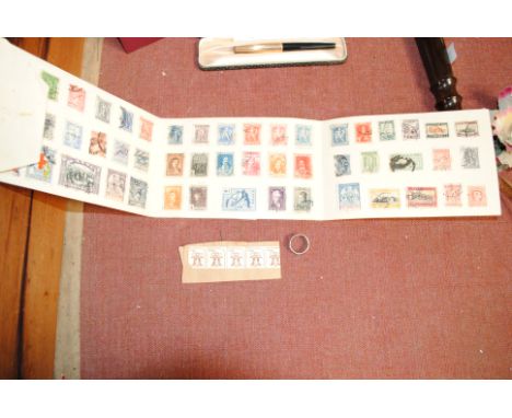 A small folder of stamps and a white metal filigree work ring