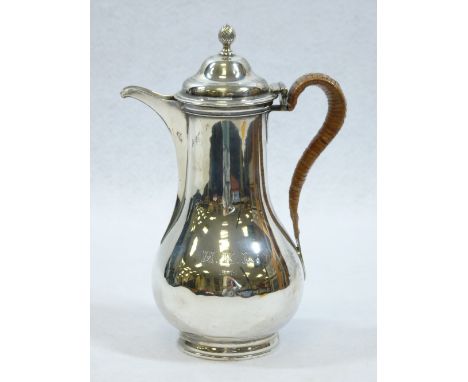 SILVER COFFEE POT - of bulbous form with narrow neck and hinged lid with swirled knop, on a short pedestal base, straw handle