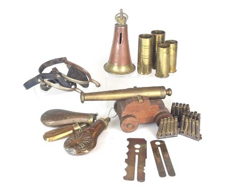 A mixed group of militaria comprising three powder flasks, including an example by C&amp;J. W. Hawksley, a shell-moulded exam